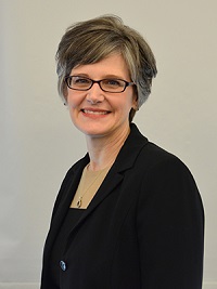 Portrait of a woman wearing glasses and a black suit